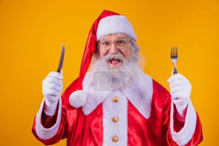 Père Noël tenant un couteau et une fourchette