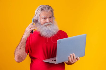 Photo for Old man on yellow background making a video call on the laptop. - Royalty Free Image
