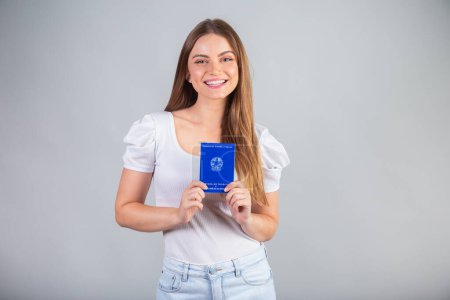Photo for Blond Brazilian woman holding National Work and Social Security Card. Translation in English (Employment Card and Social Security) - Royalty Free Image