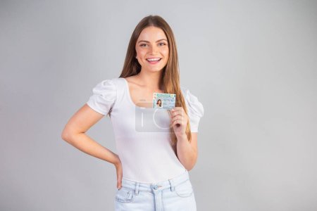Photo for Blonde Brazilian woman holding a motor vehicle driver's license. Translation in English (national driver's license) - Royalty Free Image