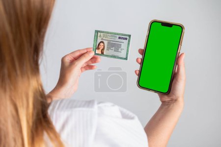 Photo for Blond Brazilian woman holding RG, Identity Card and smartphone. Translation in English (National Identity Card) - Royalty Free Image
