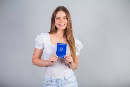 Téléchargez les photos : Femme brésilienne blonde titulaire d'une carte nationale de travail et de sécurité sociale. Traduction en anglais (carte d'emploi et sécurité sociale) - en image libre de droit