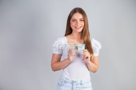 Photo for Blonde Brazilian woman holding RG, Identity Registration. Translation in English (National Identity Card) - Royalty Free Image