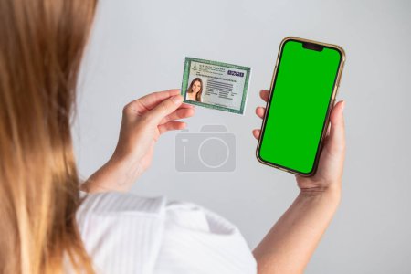 Photo for Blond Brazilian woman holding RG, Identity Card and smartphone. Translation in English (National Identity Card) - Royalty Free Image