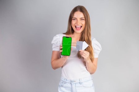 Photo for Blonde Brazilian woman showing smartphone and credit cards. - Royalty Free Image