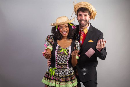 Foto de Retrato, pareja brasileña en ropa de fiesta junina. Festival de San Juan. llamando con las manos. - Imagen libre de derechos