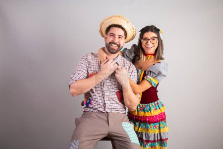Téléchargez les photos : Couple brésilien vêtu de vêtements de fête junina, fête de So Joo étreignant portrait. - en image libre de droit