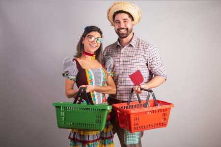 Téléchargez les photos : Couple brésilien vêtu de vêtements de fête junina, fête de So Joo avec panier de supermarché. - en image libre de droit