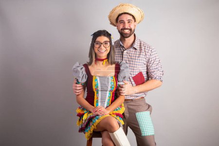 Foto de Pareja brasileña vestida con ropa de fiesta junina, fiesta de So Joo abrazando retrato. - Imagen libre de derechos