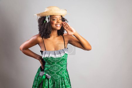 Photo for Portrait, Black Brazilian woman in festa junina clothes. Saint John's festival. shouting, announcing loudly. - Royalty Free Image