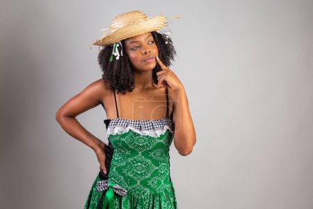 Photo for Portrait, Black Brazilian woman in festa junina clothes. Saint John's festival. thinking. - Royalty Free Image