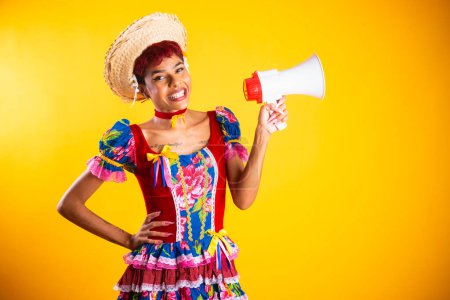 Foto de Mujer brasileña con ropa de fiesta junina. Arraial, Fiesta de San Juan. con portátil, con megáfono. - Imagen libre de derechos