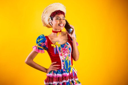 Foto de Mujer brasileña con ropa de fiesta junina. Arraial, Fiesta de San Juan. con smartphone, - Imagen libre de derechos