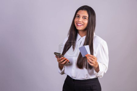 Photo for Brazilian woman holding smartphone, mobile and credit cards. - Royalty Free Image