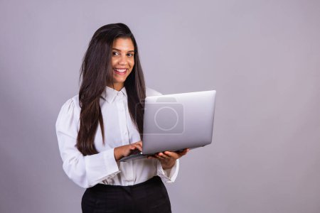 Photo for Brazilian woman holding notebook, laptop computer. - Royalty Free Image