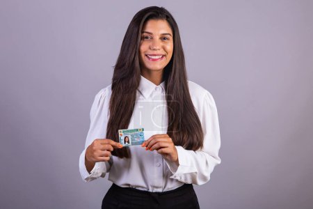 Téléchargez les photos : Femme d'affaires brésilienne avec permis de conduire. Traduction en anglais (permis de conduire national) - en image libre de droit
