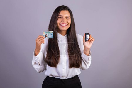 Photo for Brazilian businesswoman with driver's license and car key. Translation in English (national driver's license) - Royalty Free Image