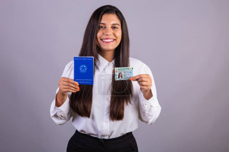 Brazilian woman holding work permits and driver's license. Translation in English (national driver's license) (Employment Card and Social Security)