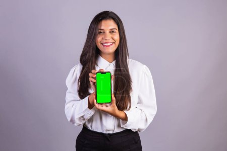 Foto de Mujer brasileña sosteniendo smartphone, móvil. pantalla verde. - Imagen libre de derechos