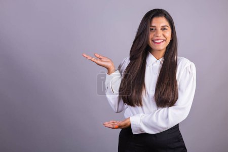 Photo for Brazilian businesswoman, manager, corporate portrait. presenting space for advertisement, publicity or product. pointing out. - Royalty Free Image