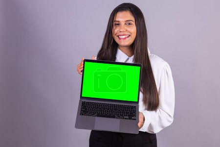 Foto de Mujer brasileña sosteniendo portátil con pantalla verde. - Imagen libre de derechos