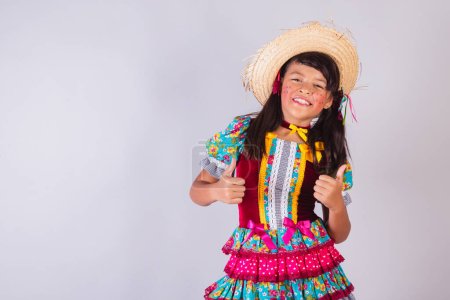 Téléchargez les photos : Enfant, fille brésilienne, avec des vêtements de fête de juin, comme avec les doigts. - en image libre de droit
