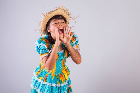 Téléchargez les photos : Enfant, fille brésilienne, avec des vêtements Festa Junina, criant promotion, discount. - en image libre de droit