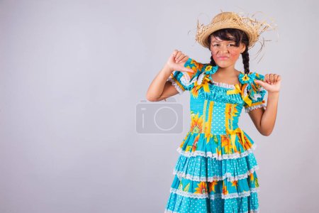 Téléchargez les photos : Enfant, fille brésilienne, avec des vêtements de fête de juin, genre, pouce levé. - en image libre de droit