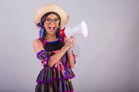 Foto de Mujer brasileña con ropa de fiesta junina. celebración de megáfono, anunciando anuncios. - Imagen libre de derechos