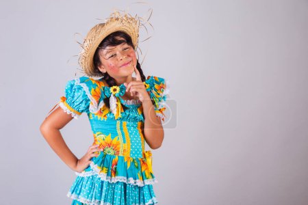 Foto de Niño, chica brasileña, en ropa de fiesta junina, pensando - Imagen libre de derechos