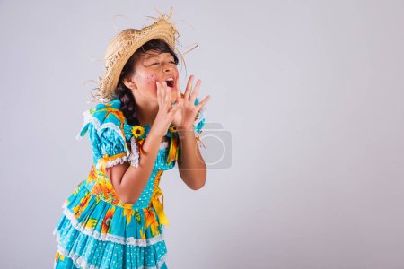 Téléchargez les photos : Enfant, fille brésilienne, avec des vêtements Festa Junina, criant promotion, discount. - en image libre de droit