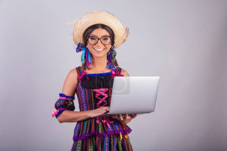 Photo for Brazilian woman with festa junina clothes. with notebook - Royalty Free Image