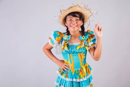 Foto de Niño, chica brasileña, con ropa Festa Junina, dedos cruzados, signo de la suerte, animando. - Imagen libre de derechos