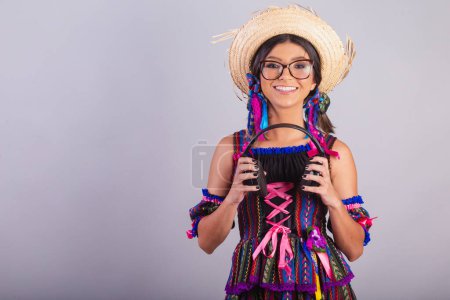 Photo for Brazilian woman with festa junina clothes. holding headphones. - Royalty Free Image