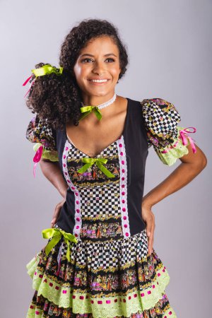 Photo for Black Brazilian woman wearing festa junina clothes. Fellowship of Saint John. Arraial, Vertical portrait. - Royalty Free Image