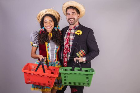 Téléchargez les photos : Couple brésilien, portant des vêtements de fête de juin, fraternisation au nom de So Joo, Arraial. avec panier d'épicerie, épicerie. - en image libre de droit