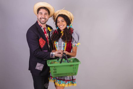 Téléchargez les photos : Couple brésilien, portant des vêtements de fête de juin, fraternisation au nom de So Joo, Arraial. avec panier d'épicerie, épicerie - en image libre de droit