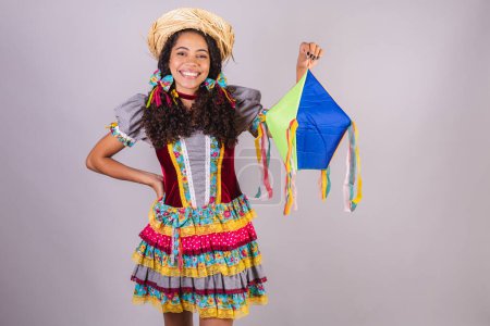Foto de Negra, brasileña, vestida con ropa de fiesta de junio, fraternización en nombre de So Joo, Arraial. Gritando sosteniendo globo, decoración - Imagen libre de derechos