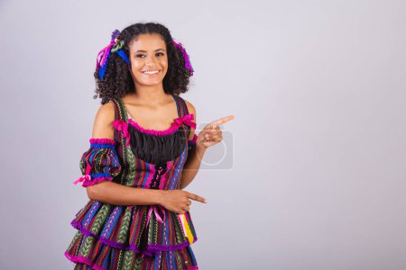 Foto de Mujer brasileña negra con ropa de fiesta junina. Comunidad de San Juan. Arraial, presentación de producto o publicidad. - Imagen libre de derechos