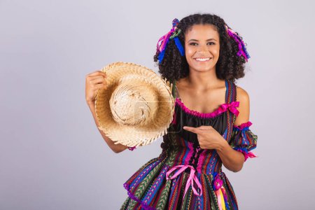 Foto de Mujer brasileña negra con ropa de fiesta junina. Comunidad de San Juan. Arraial, con sombrero de paja. - Imagen libre de derechos