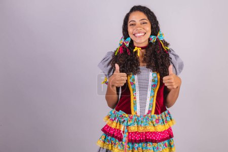 Téléchargez les photos : Femme brésilienne noire portant des vêtements de fête de juin, fraternisation au nom de So Joo. au camp. comme signe avec les mains. - en image libre de droit
