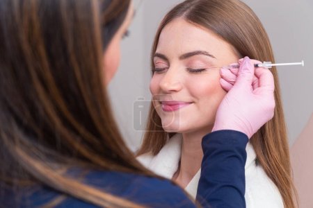 Photo for Woman wearing bathrobe in beauty clinic, aesthetics, patient, cosmetic procedures. botox application. anti wrinkle and anti aging. - Royalty Free Image