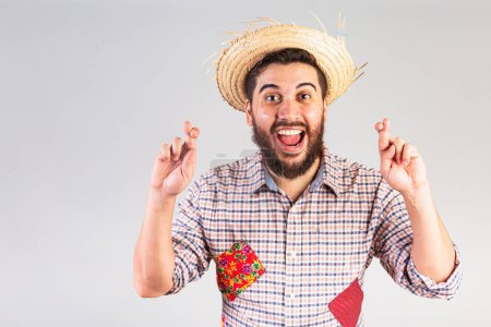 Foto de Hombre brasileño vistiendo ropa de fiesta junina. Arraial, Fiesta de San Juan. dedos cruzados, signo de la suerte, animando, deseando. - Imagen libre de derechos