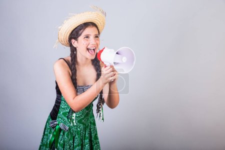 Girl, Brazilian, with clothes from Festa Junina, Arraial, Festa de So Joao. Horizontal portrait. With megaphone, advertising promotion.