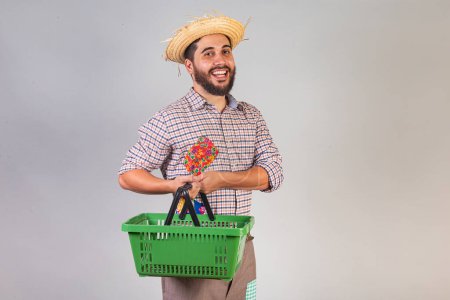 Téléchargez les photos : Homme brésilien portant des vêtements de fête junina. Arraial, fête de Saint-Jean. avec panier de supermarché. - en image libre de droit