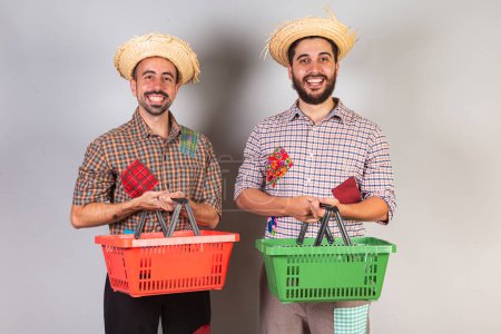 Foto de Hombres, amigos, brasileños con ropa de Festa Junina. Arraial, Fiesta de San Juan. con cesta de supermercado. - Imagen libre de derechos