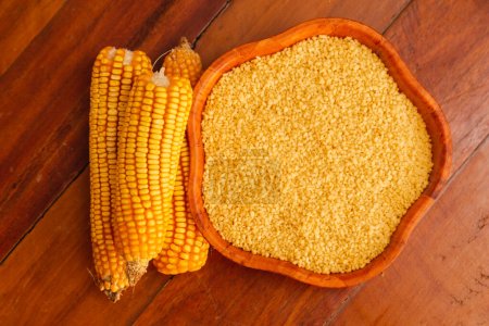 maíz, hojuelas y maíz, en un tazón sobre un fondo de madera