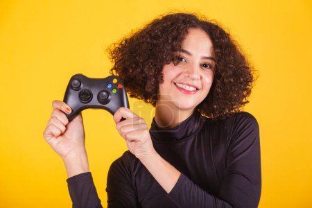 Photo for Caucasian model, in black shirt and blue jeans, holding joystick, gamer. fun. - Royalty Free Image