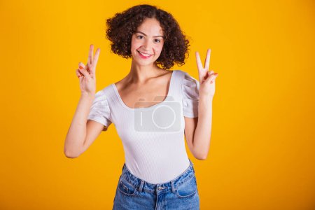 Photo for Caucasian model, with white shirt and blue jeans, peace and love. - Royalty Free Image