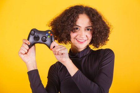 Photo for Caucasian model, in black shirt and blue jeans, holding joystick, gamer. fun. - Royalty Free Image